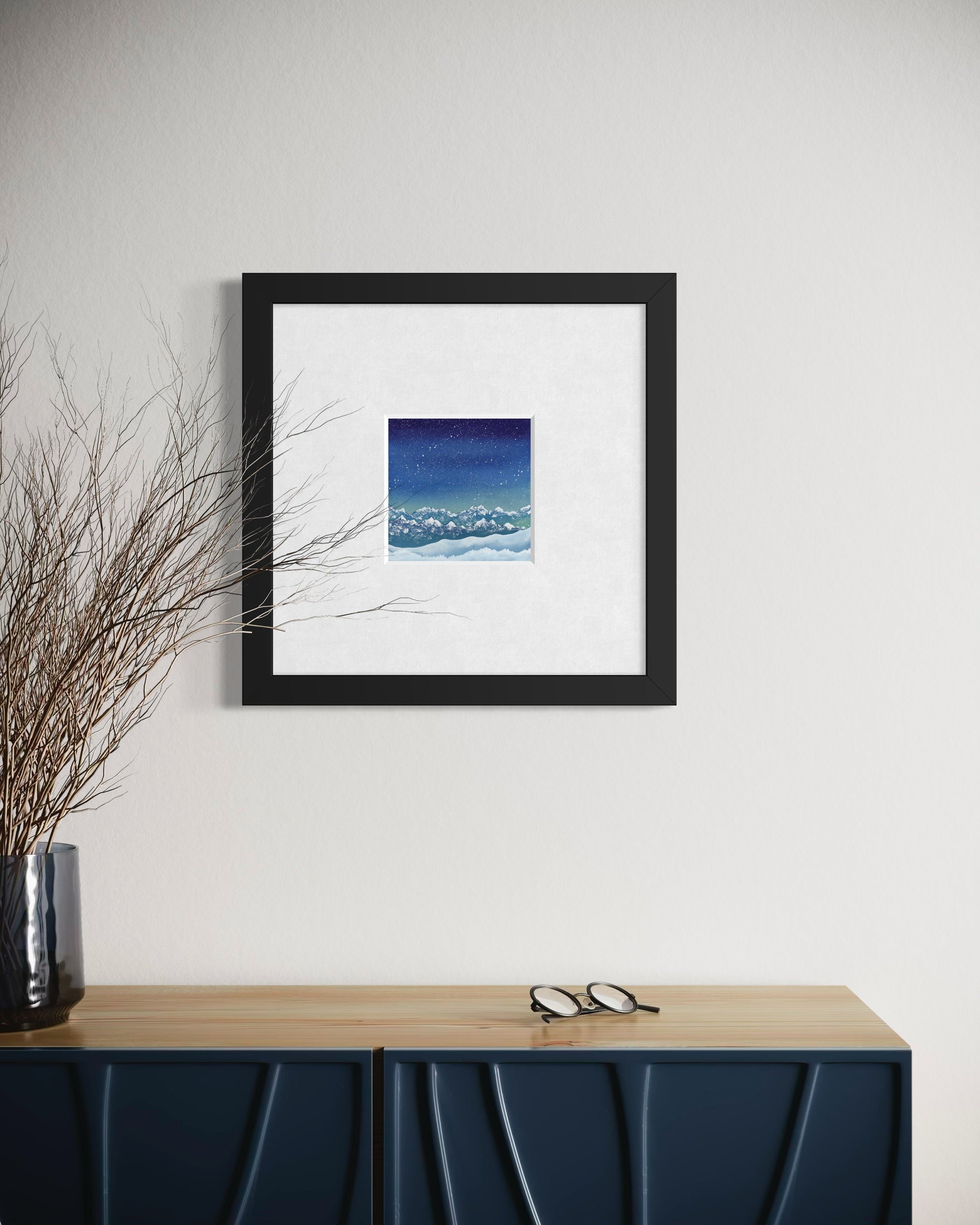 Framed artwork on a wall above a console table with decorative elements.