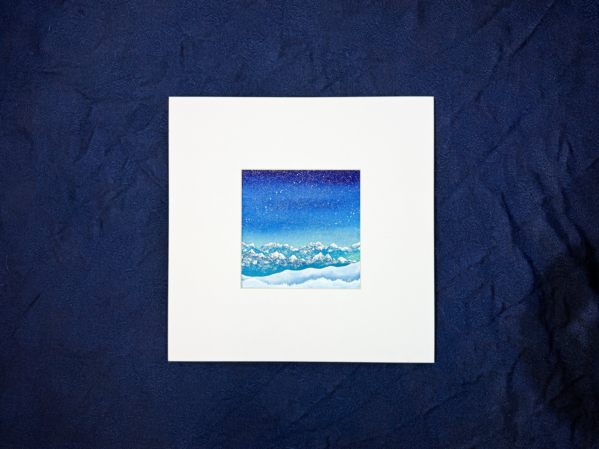 Framed artwork of a blue sky with clouds on a dark blue textured background