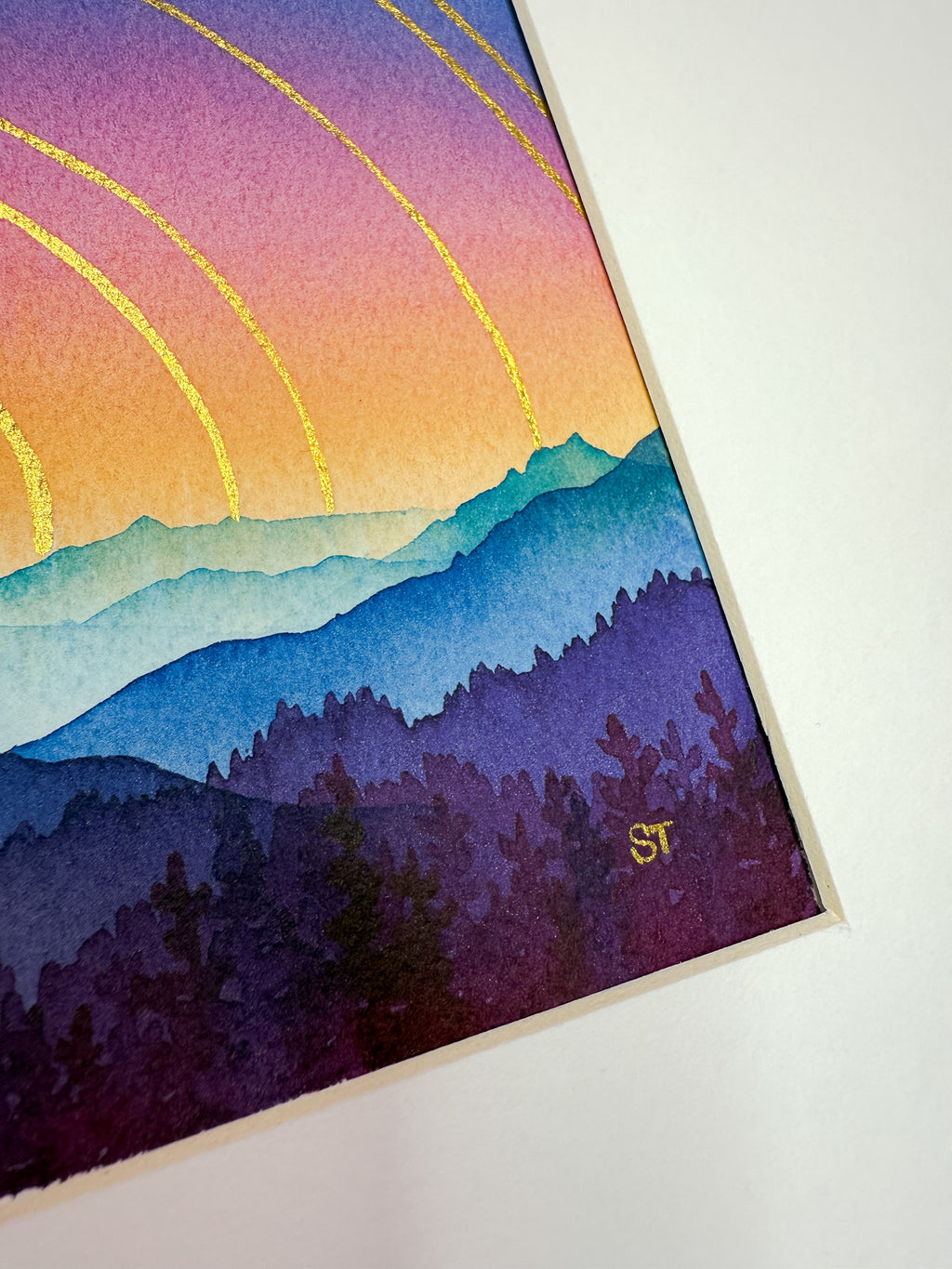 Colorful mountain landscape with a rainbow and silhouette of trees on a white background