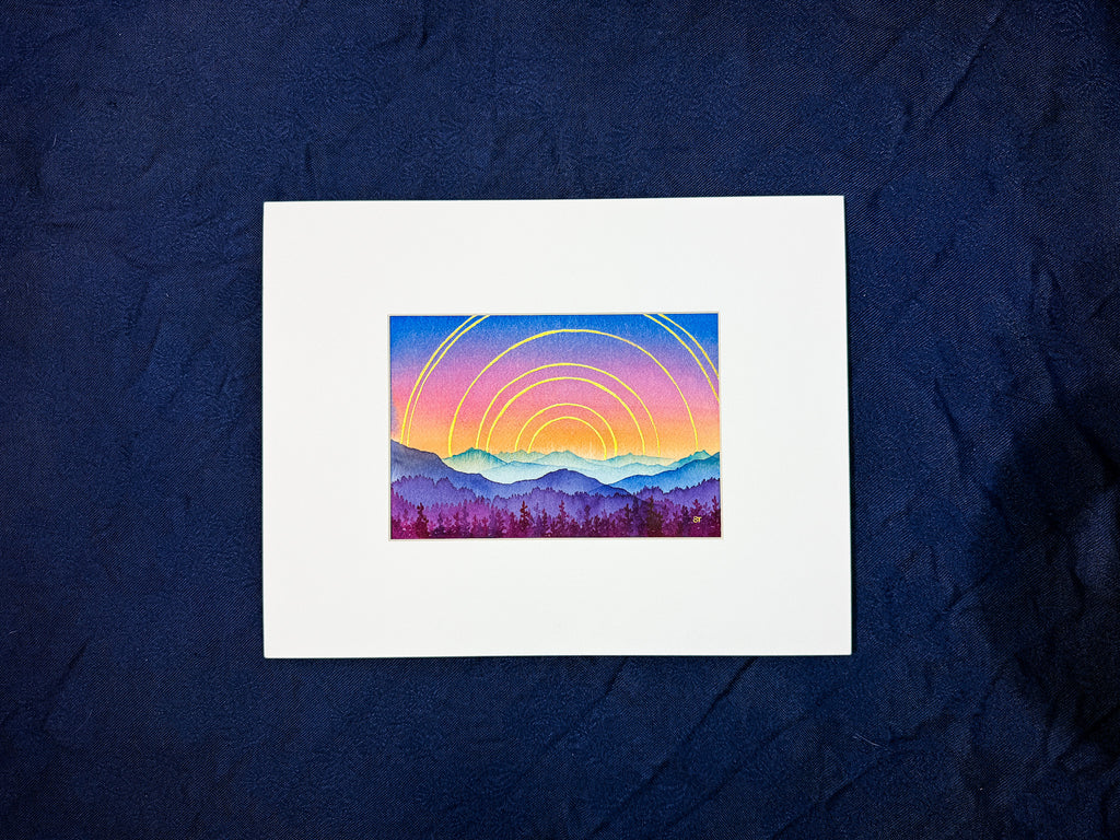 Art print of a colorful mountain landscape with concentric circles on a dark blue fabric background.