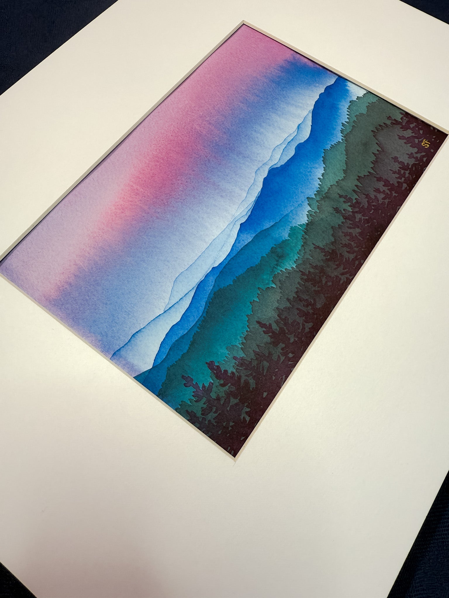 Colorful abstract mountain landscape watercolor painting in a white mat. 